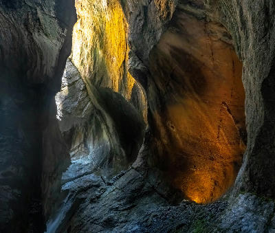 Light shining onto smooth rock walls inside Trümmelbach Falls in a narrow mountain gorge in Lauterbrunnen Switzerland