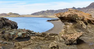 Rock formations overlooking Kleifarvatn lake with volcanic mountains in the background on the Reykjanes Peninsula, Iceland.