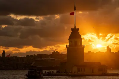 Maiden’s Tower silhouetted against an orange sunset over the Bosphorus in Istanbul, Turkey.