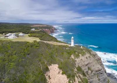 Aerial view of Cape Otway Lightstation, surrounding buildings, coastal cliffs and Southern Ocean in Victoria, Australia.