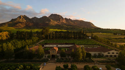 Aerial view of Waterford Estate vineyards and winery buildings framed by the Helderberg Mountains in Stellenbosch, Cape Winelands, South Africa.