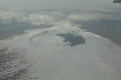 Aerial winter view of Nemrut Crater Lake surrounded by the snow-covered volcanic caldera of Mount Nemrut near Tatvan, Turkey.