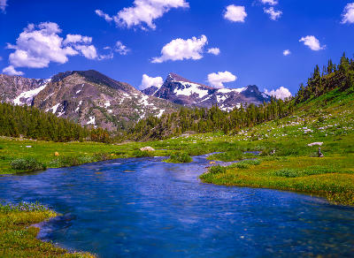 Stream flowing through Tuolumne Meadows with Sierra peaks in Yosemite National Park, California.