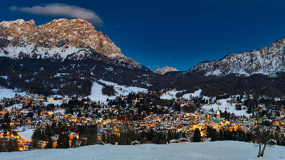 Snow-covered Cortina d'Ampezzo town at blue hour in the Dolomites, Italy.