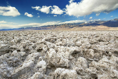 Rough salt formations at Devils Golf Course in Death Valley National Park California with rugged salt textures and mountains in background