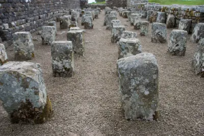 Close-up of rows of ancient stone floor supports inside the granary ruins at Housesteads Roman Fort, Northumberland.