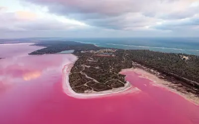 Aerial view of pink Hutt Lagoon separated from the blue Indian Ocean by a narrow coastal strip.