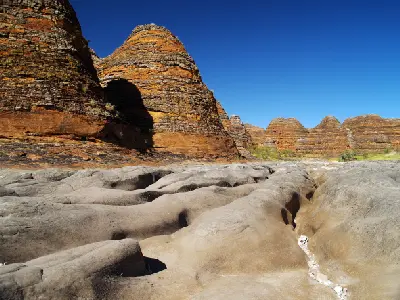 Eroded channels in the dry bed of Piccaninny Creek lead between the striped sandstone domes of the Bungle Bungle Range.