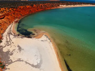 Aerial view of vivid red coastal cliffs, pale beaches and turquoise water in Francois Peron National Park.