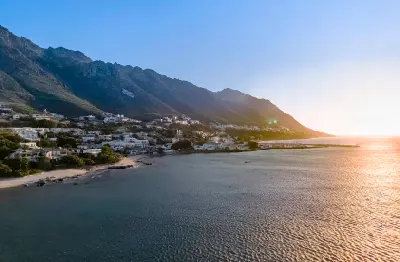 Aerial view of Gordon's Bay at sunset with False Bay, coastal homes and the Hottentots-Holland Mountains in the background.