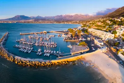 Aerial sunset view of Gordon's Bay Harbour, marina and waterfront with the Hottentots-Holland Mountains and False Bay in the background.