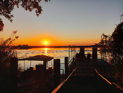 Sunset over the Chobe River with safari boats moored along the Chobe Riverfront in Botswana.