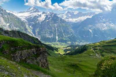 View over Grindelwald Valley from Grindelwald First with alpine slopes and surrounding peaks, Switzerland.