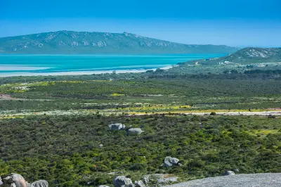 View across West Coast National Park towards the turquoise waters of Langebaan Lagoon, with fynbos landscapes and seasonal wildflowers in the foreground.