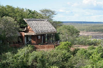 Thatched accommodation at Letaba Rest Camp surrounded by riverine vegetation overlooking the Letaba River valley in Kruger National Park.