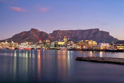 V&A Waterfront harbour with Table Mountain at sunset in Cape Town, South Africa.