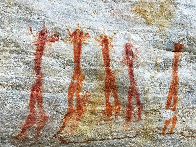 Ancient San rock art depicting elongated female figures painted on a sandstone rock shelter wall in the Cederberg Mountains, Western Cape, South Africa.
