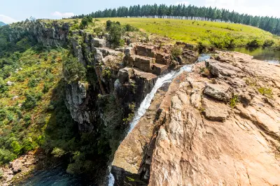 View from the top of Berlin Falls showing the river flowing over rocky cliffs into the deep gorge below near Graskop.