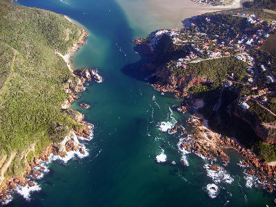 Aerial view of the Knysna Heads and lagoon entrance on the Garden Route, showing forested cliffs, rocky coastline and the connection between the Knysna Lagoon and Indian Ocean.