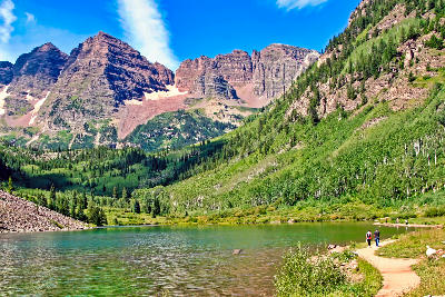 People walking beside Maroon Lake with Maroon Bells mountains in Aspen Colorado