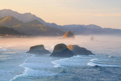 Sea stacks and rolling waves at sunrise off Cannon Beach on the Oregon Coast.