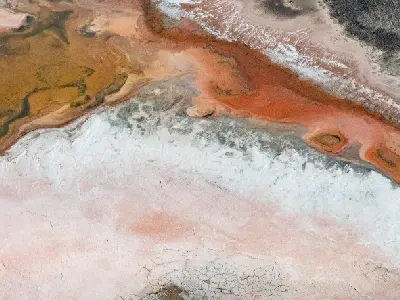 Aerial view of pink, orange and white salt patterns along the edge of Hutt Lagoon.