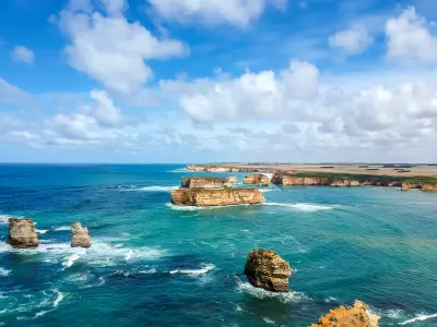 Wide aerial view of limestone sea stacks and coastal cliffs at Bay of Islands, Victoria, Australia.