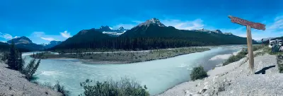 Panoramic view of Athabasca River winding through valley with mountains along Icefields Parkway