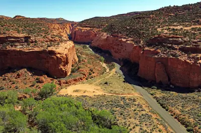 Burr Trail Road winds between towering red sandstone cliffs as it enters Long Canyon in southern Utah.