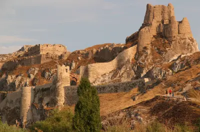 Stone walls, entrance gate and ancient towers of Van Castle climbing across a rugged rocky ridge in eastern Turkey.