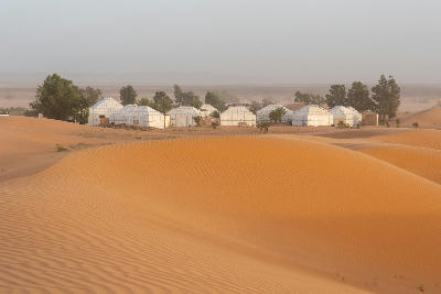Desert camp and sand dunes near Merzouga in the Sahara Desert of Morocco.