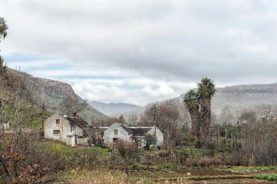 Historic whitewashed cottages surrounded by gardens and trees in Wupperthal, set within a remote mountain valley of the northern Cederberg.
