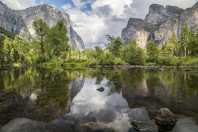 Reflections of granite cliffs and trees in the Merced River in Yosemite Valley, Yosemite National Park, California.