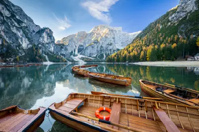 Landscape view of Lago di Braies surrounded by forest and Dolomite mountain peaks in northern Italy.
