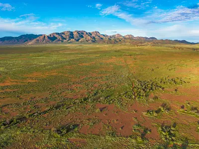 Aerial view of the Elder Range above green and red plains near Moralana Scenic Drive in the Flinders Ranges, South Australia.