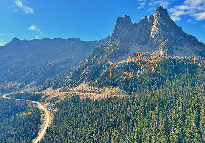 Washington Pass with winding road, golden larch trees and Liberty Bell mountain spires in North Cascades
