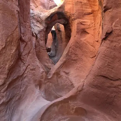Sculpted red sandstone forms a series of natural arches and twisting passages inside Peek-a-Boo Slot Canyon.
