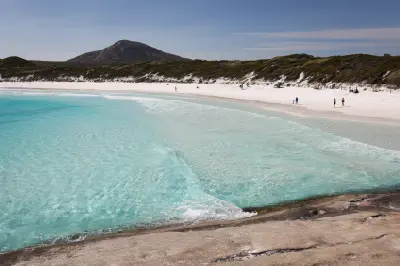 Turquoise water and white sand at Hellfire Bay with granite peaks behind, Cape Le Grand National Park, Western Australia.