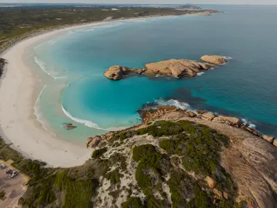 Aerial view of Twilight Beach showing white sand, turquoise water, granite formations and coastal heath near Esperance, Western Australia.