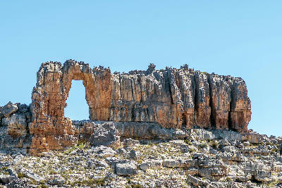 Wolfberg Arch sandstone formation rising above rocky terrain in the Cederberg Wilderness near Sanddrif, Western Cape, South Africa.