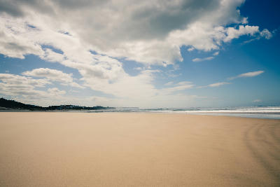 Wide sandy beach at Wilderness on South Africa’s Garden Route, with rolling Indian Ocean waves, expansive shoreline and dramatic cloud-filled skies.