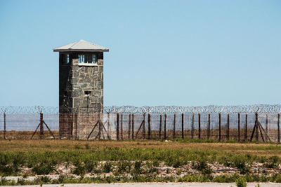 Guard tower and barbed wire fence at Robben Island prison near Cape Town, South Africa.