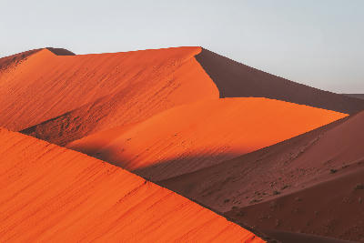 Sunlit red sand ridges and shadowed dune faces on Dune 45 in the Sossusvlei region of Namibia.