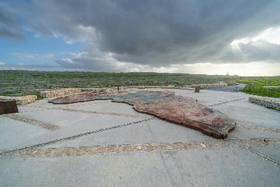 Cape Agulhas southernmost point monument beneath dramatic storm clouds in the Western Cape, South Africa.