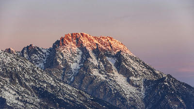 Alpenglow on the Teton Range at sunrise viewed from Glacier View Turnout, Grand Teton National Park, Wyoming, USA.