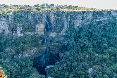 Panorama Falls dropping into Graskop Gorge below cliff-top adventure activities and indigenous forest near Graskop, Mpumalanga.