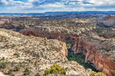 Sweeping view across layered sandstone cliffs, deep red-rock canyons and desert plateaus in Grand Staircase–Escalante National Monument.