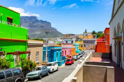 Brightly painted houses along a narrow street in Bo-Kaap with Table Mountain in the background, Cape Town, South Africa.