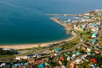 Aerial view of Santos Beach in Mossel Bay, showing the sandy beach, sheltered bay, harbour breakwaters and surrounding coastal townscape on South Africa's Garden Route.
