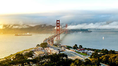 Golden Gate Bridge with fog rolling across the span and traffic approaching from the San Francisco side